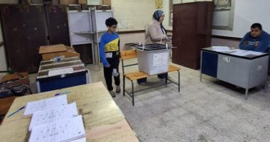 سيدة تصطحب نجلها في الساعات الأخيرة قبل غلق التصويت بحدائق القبة