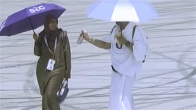 زوج يرش المياه على وجه زوجته في مشهد إنساني مؤثر بجبل عرفات خلال أداء مناسك الحج